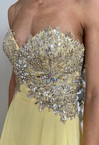 Tony Bowls TON115507 Prom gown has an A-Line style with Empire waist, strapless, chiffon overlay, fully beaded bodice, fully lined , Zipper closure. yellow